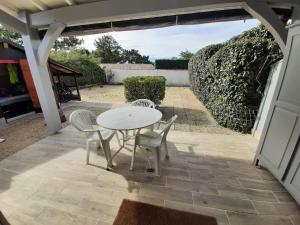 a white table and chairs on a patio at Villa Patio Charmante, 2 Pas des Plages, Terrasse, Parking, Piste Cyclable - FR-1-239-892 in Capbreton