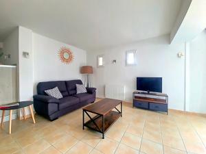 sala de estar con sofá y TV en Appartement Saintes-Maries-de-la-Mer, 3 pièces, 4 personnes - FR-1-475-110, en Saintes-Maries-de-la-Mer