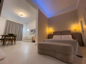 una camera da letto con un letto, un divano e un tavolo di Ritucci Suite a Lecce