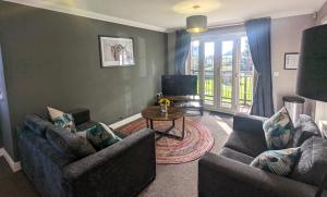 a living room with two couches and a table at Superb Modern Apartment, FREE Secure Parking! in Allesley