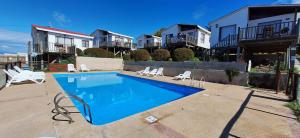 a swimming pool in front of some houses at Rocas del Pirata in Quintero