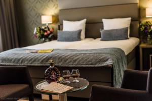 una camera d'albergo con un letto e due bicchieri di vino di OZO Hotels Arena Amsterdam ad Amsterdam