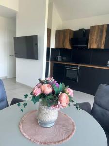 a vase with pink flowers sitting on a table at Wohnung mit Garten Nähe Legoland in Leipheim