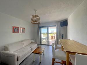 uma sala de estar com um sofá branco e uma mesa em Appartement Saintes-Maries-de-la-Mer, 2 pièces, 4 personnes - FR-1-475-111 em Saintes-Maries-de-la-Mer