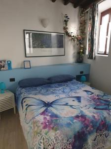 een slaapkamer met een bed met een vlinderdeken bij Le Tre Arti in Gavirate