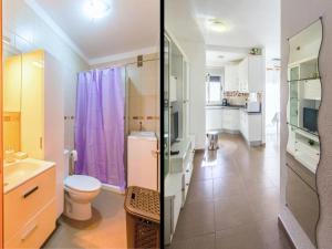 baño con cortina de ducha púrpura y aseo en Live La Laguna Heraclio, en La Laguna 6 fotos más