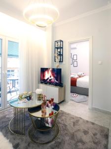 a living room with a fireplace and a bedroom at Psimithefto Luxury Apartments in Thessaloniki