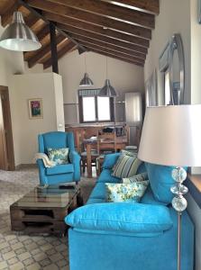 Una sala de estar con un sofá azul y sillas. en La Fragua, en Nueva de Llanes