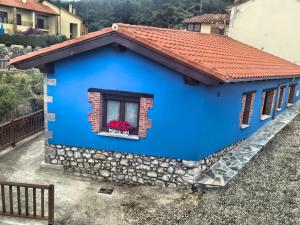 a blue house with a red roof at La Fragua in Nueva de Llanes