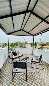 a patio with two chairs and a hammock at Baie du Tombeau Apartment in Baie du Tombeau