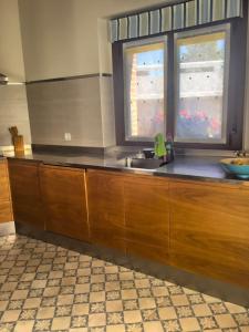 a kitchen with a sink and two windows at La Fragua in Nueva de Llanes