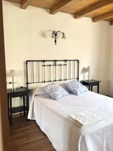 1 dormitorio con 1 cama blanca y 2 mesas en La Fragua, en Nueva de Llanes 4 fotos más