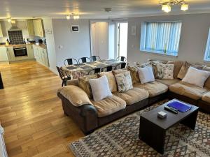 uma sala de estar com um sofá e uma mesa em The Dairy, Bramble Farm Cottages em Ferndown