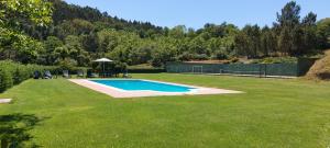 duży dziedziniec z basenem w trawie w obiekcie Casa Quinta das Vessadas w mieście Celorico de Basto