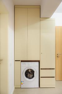 a washer and dryer in a room with white cabinets at NEW Luxury City Center Studio in Bucharest +14 photos