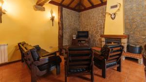 a living room with leather chairs and a fireplace at Casa Quinta das Vessadas in Celorico de Basto