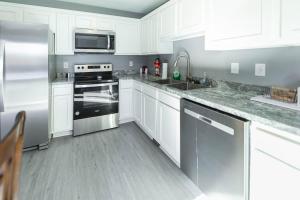 a kitchen with white cabinets and stainless steel appliances at Memorial Field Lodge in Bloomington