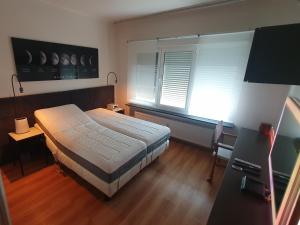 een slaapkamer met een groot bed en 2 ramen bij Olympiade Bridge Penthouse 2 bedroom and outside of low emission zone in Antwerpen