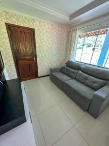 a living room with a couch and a window at Flat Chácara Olhos D’Água in Gaspar