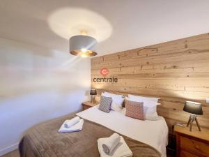 a bedroom with a large bed with a wooden headboard at Appartement Les Gets, 4 pièces, 6 personnes - FR-1-454A-17 in Les Gets