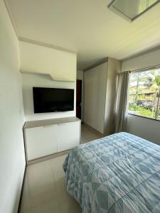 1 dormitorio con 1 cama y TV de pantalla plana en Flat Chácara Olhos D’Água en Gaspar