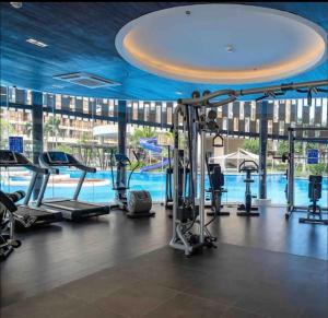 a gym with a pool in the background at Budget Private Studio with Free Luxurious Pool and Gym by SYM B625 in Phnom Penh