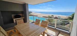a balcony with a table and chairs and a view of the beach at Oceanic Breeze in Margate