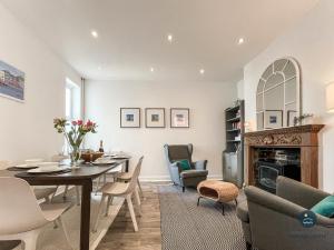 a dining room with a table and chairs and a fireplace at Sanderlings - holiday home close to beach in Weymouth