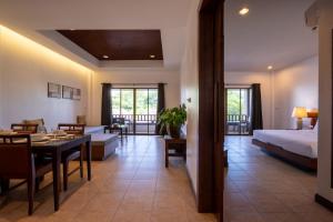 a hotel room with a bed and a dining room at RB Resort in Pattaya Central