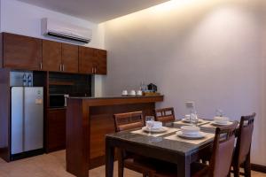 een keuken met een tafel met stoelen en een koelkast bij RB Resort in Pattaya