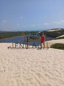 a man sitting in a chair on the beach at Casanostra44 in Genipabu