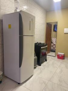 a white refrigerator in a room with a table at CASA ATALAIA 2 SUITES Salinopolis in Salinópolis