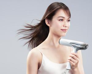 a young woman holding a hair dryer at Richmond Hotel Yokohama-Bashamichi in Yokohama