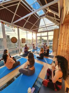 un grupo de personas sentadas en una clase de yoga en Mandala Yoga Hostel, en Bogotá