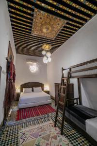 a bedroom with two bunk beds and a chandelier at Riad Fes Tala in Fez