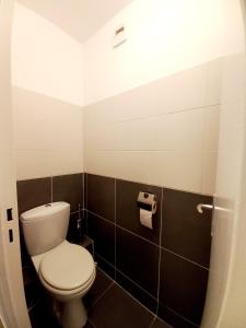 La salle de bains est pourvue de toilettes et de carrelage noir et blanc. dans l'établissement T3 - PARIS 10' Confort & Modern - Terrasse - Parking - WIFI, à Gentilly
