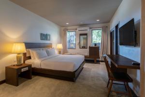 a bedroom with a bed and a desk and a computer at RB Resort in Pattaya Central