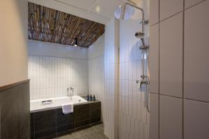 een badkamer met douche en ligbad bij RB Resort in Pattaya +35 foto's