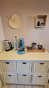 a kitchen counter with baskets and a coffee maker on it at Le Cosy Home in Oyonnax