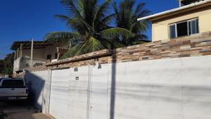 a white garage with a fence in front of a house at Residencial Caetano em Porto de Galinhas in Porto De Galinhas