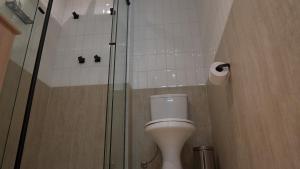 a bathroom with a toilet and a glass shower at Apê Pátio Paulista in São Paulo