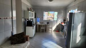 a kitchen with a refrigerator and a table at Residencial Caetano em Porto de Galinhas in Porto De Galinhas