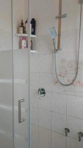 una doccia con porta in vetro in bagno di House Arrow a Latina