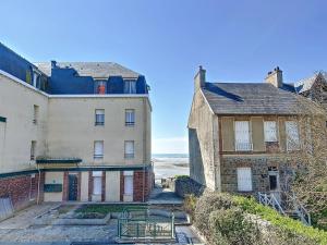two old buildings with the ocean in the background at Appartement rénové avec ascenseur - Proche plage et centre-ville - FR-1-361-506 in Saint-Pair-sur-Mer