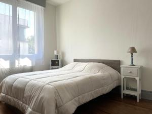 a white bedroom with a bed and a window at Appartement Royan, 3 pièces, 4 personnes - FR-1-539-52 in Royan