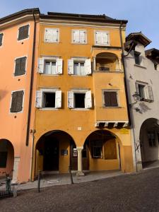 um edifício amarelo com janelas brancas numa rua em Art apartment Alla casa del Gastaldo em Gorizia