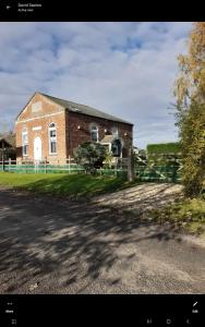 a brick building with a fence in front of it at Old Chapel House Tetney Lock in Grimsby