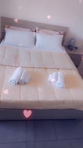 a bed with two towels and hearts on it at House Arrow in Latina