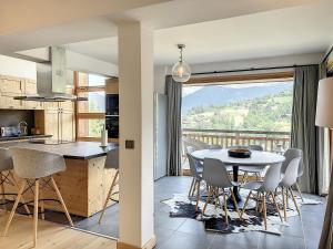 コンブルーにあるChalet de Luxe 6 Chambres avec Piscine et Bien-Être à Combloux - FR-1-560-107のテーブルと椅子のあるキッチンとダイニングルーム