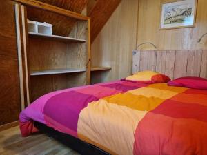 a bed in a room with a colorful blanket at Chalet climatisé grande terrasse parking privé in Coublevie